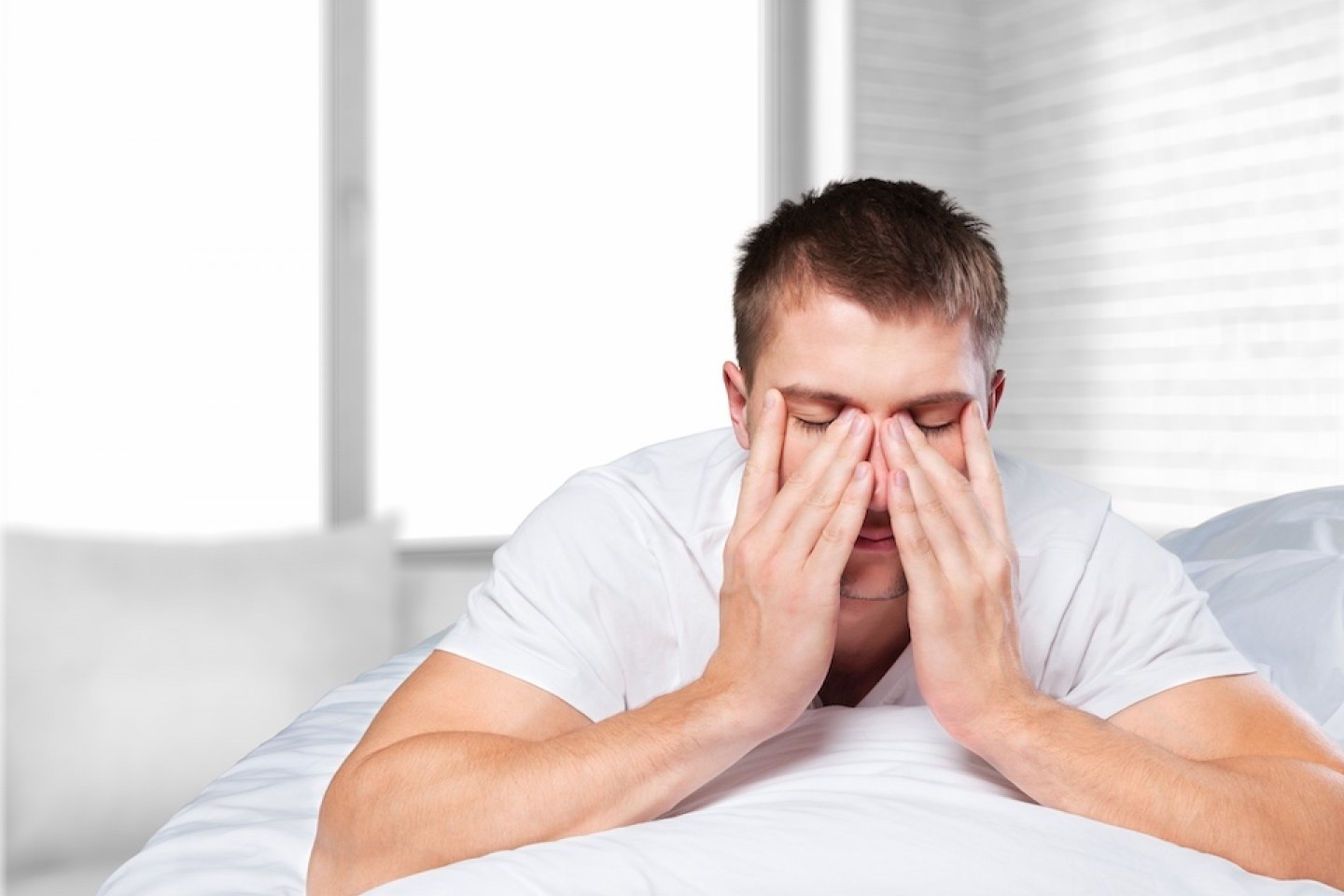 Tired man rubbing his eyes
