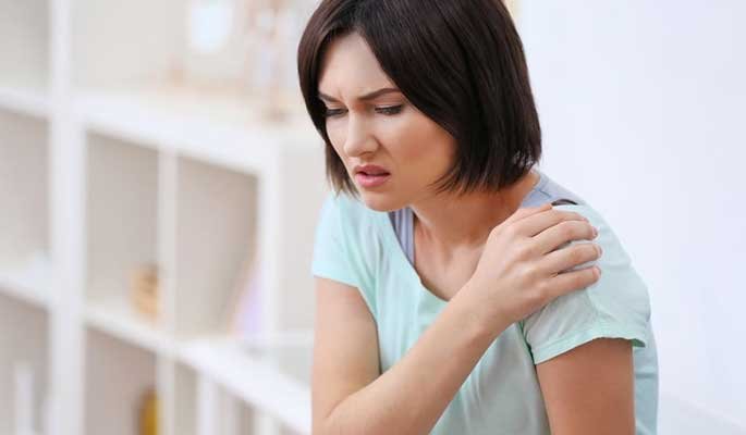 Woman touching her shoulder during an everyday comfort moment